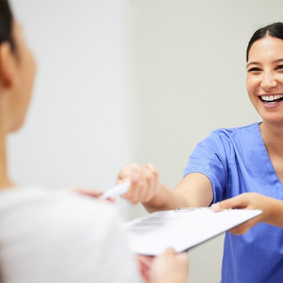 Dental receptionist helping a patient with paperwork