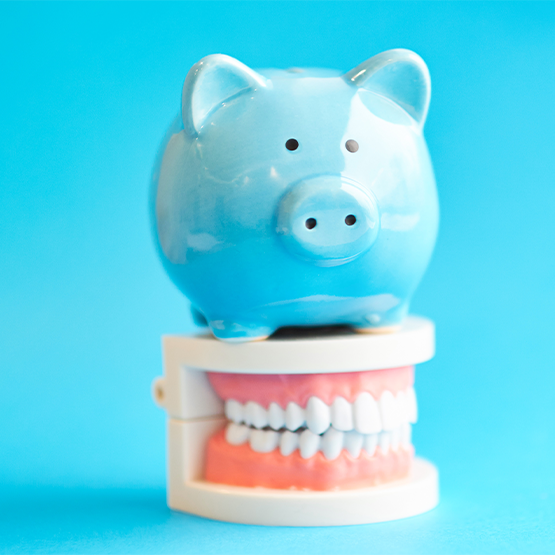 A piggy bank with teeth on a blue background, symbolizing a playful connection to dentistry.
