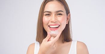 young woman holding custom made mouth trays