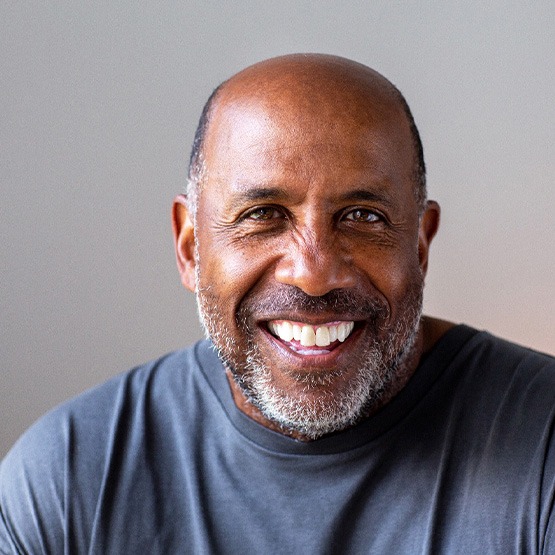 Senior man smiling in gray shirt
