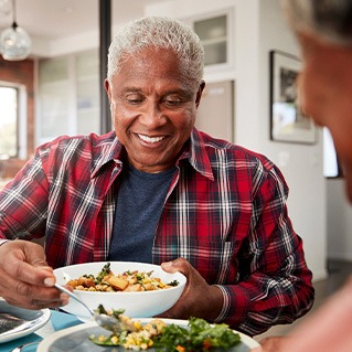 Senior man filling plate at table