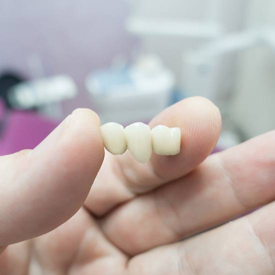 Dentist holding a dental bridge 
