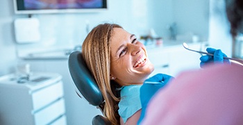 Patient smiling at dentist while sitting in treatment chair