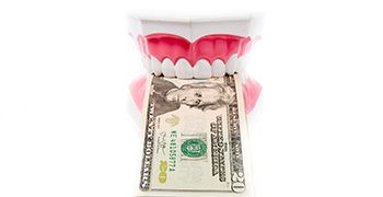 teeth holding money illustrating the cost of dental emergencies in Tallahassee
