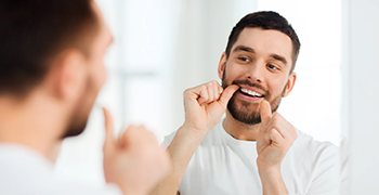 man taking care of his smile to avoid dental emergencies in Tallahassee