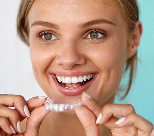 Woman Holding Smiling Holding Invisalign® Tray