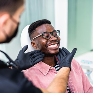 Dentist looking at patient's smile in treatment chair