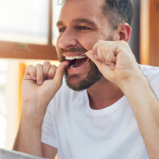 Closeup of man smiling while flossing