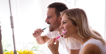 Couple brushing teeth together at home