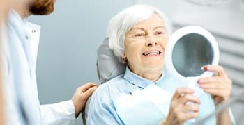 older woman smiling looking in mirror