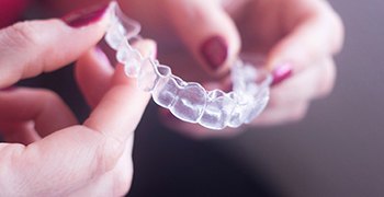 closeup of woman holding clear aligners 