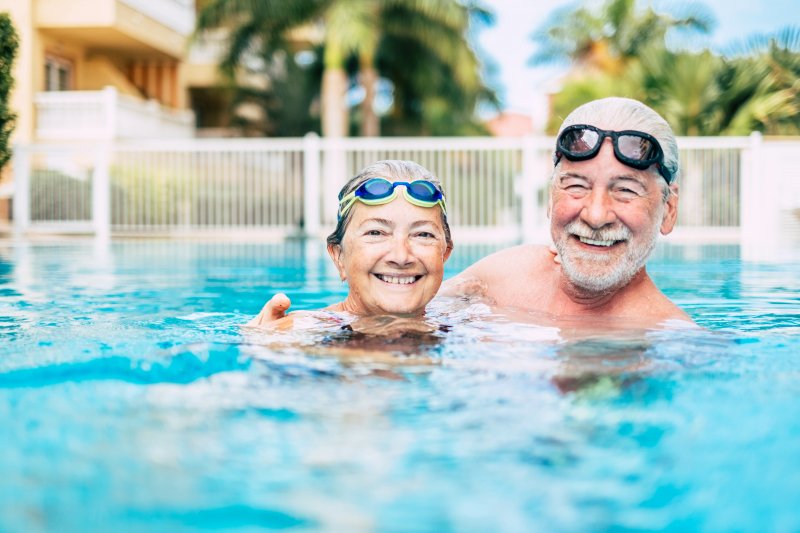 Elderly couple smiling in swimming pool