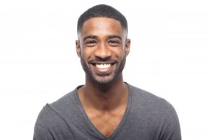 young man in black shirt smiling with perfect teeth thanks to cosmetic dentist in Tallahassee
