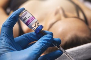 a dentist holding a vial of botulinum toxin (BOTOX)