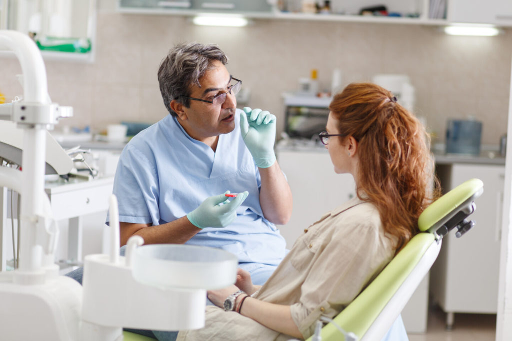 woman speaking with dentist about Invisalign benefits in Tallahassee