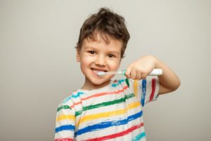 Happy young boy holding a toothbrush