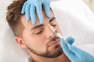 Man receiving BOTOX injection between eyebrows.